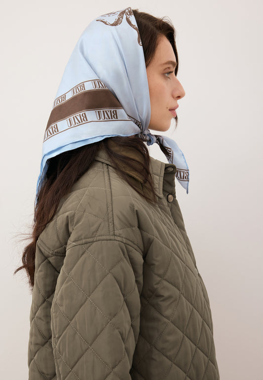 Model wearing the blue ARIA silk scarf tied around her head.