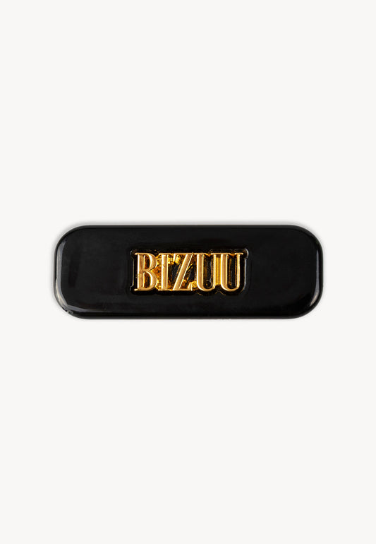 Small black CATTA hair clip with central logo.
