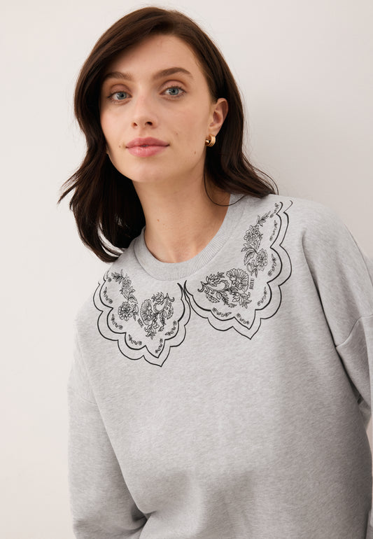 Close-up of the model wearing the gray COLLIER sweatshirt with illustrated collar.