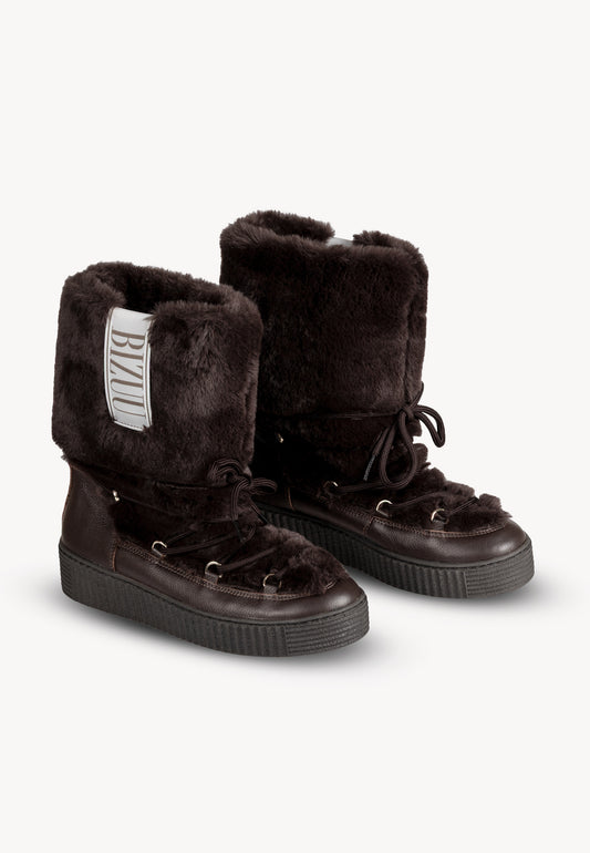 Brown fur snow boots FINN with a decorative logo patch on the upper.