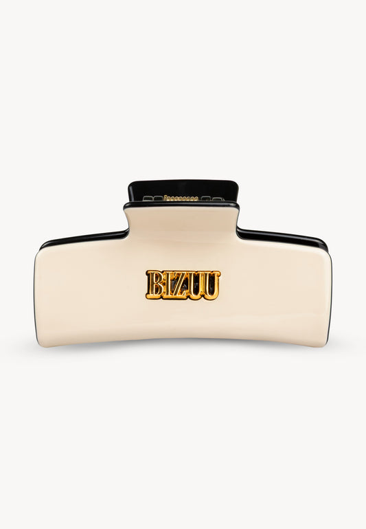 Rectangular IVORIA hair clip with black accents and gold logo.