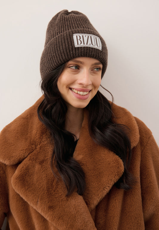 Close-up of the smiling model wearing the brown MOYU merino wool beanie.