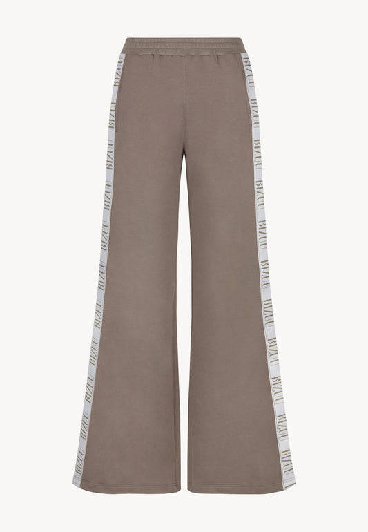 The front of PETRA's loose-fitting sweatpants with logo stripe on the legs.