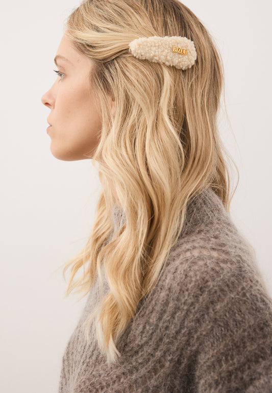 Close-up of the model’s hair styled with the cream PLUSHA shearling hair clip.