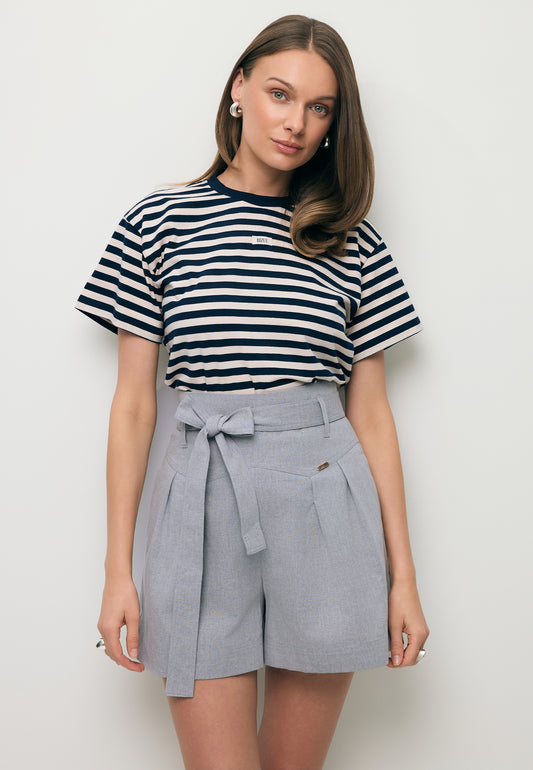 Close-up of a model wearing the TISHALLY T-shirt in white and navy stripes and the KANDYS high-waisted grey shorts.