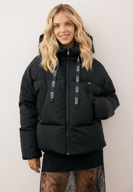 Smiling model wearing the black YOKO down jacket with branded drawstrings.