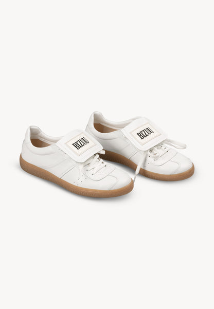 White sneakers with a rolled tongue and BIZUU MOBBY patch