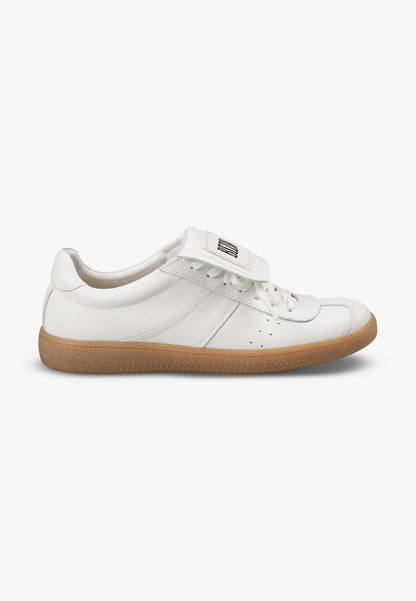 White sneakers with a rolled tongue and BIZUU MOBBY patch