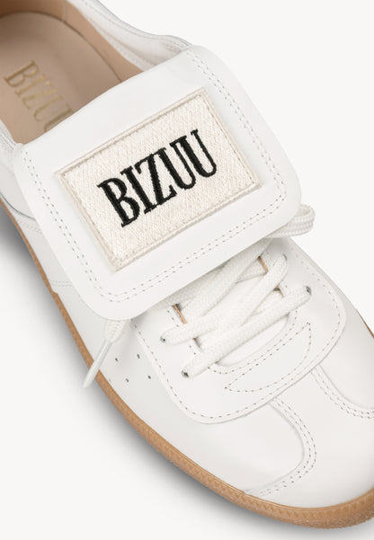 White sneakers with a rolled tongue and BIZUU MOBBY patch