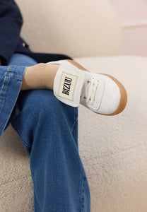 White sneakers with a rolled tongue and BIZUU MOBBY patch