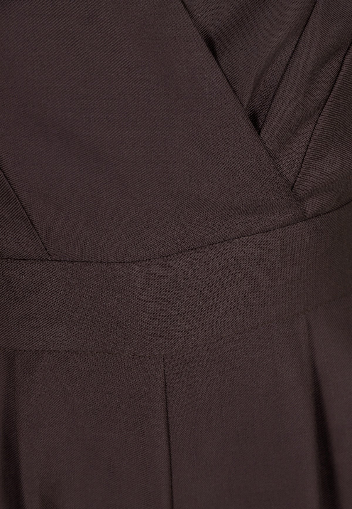 Close-up of the waist tab of the brown ARATIKA jumpsuit.