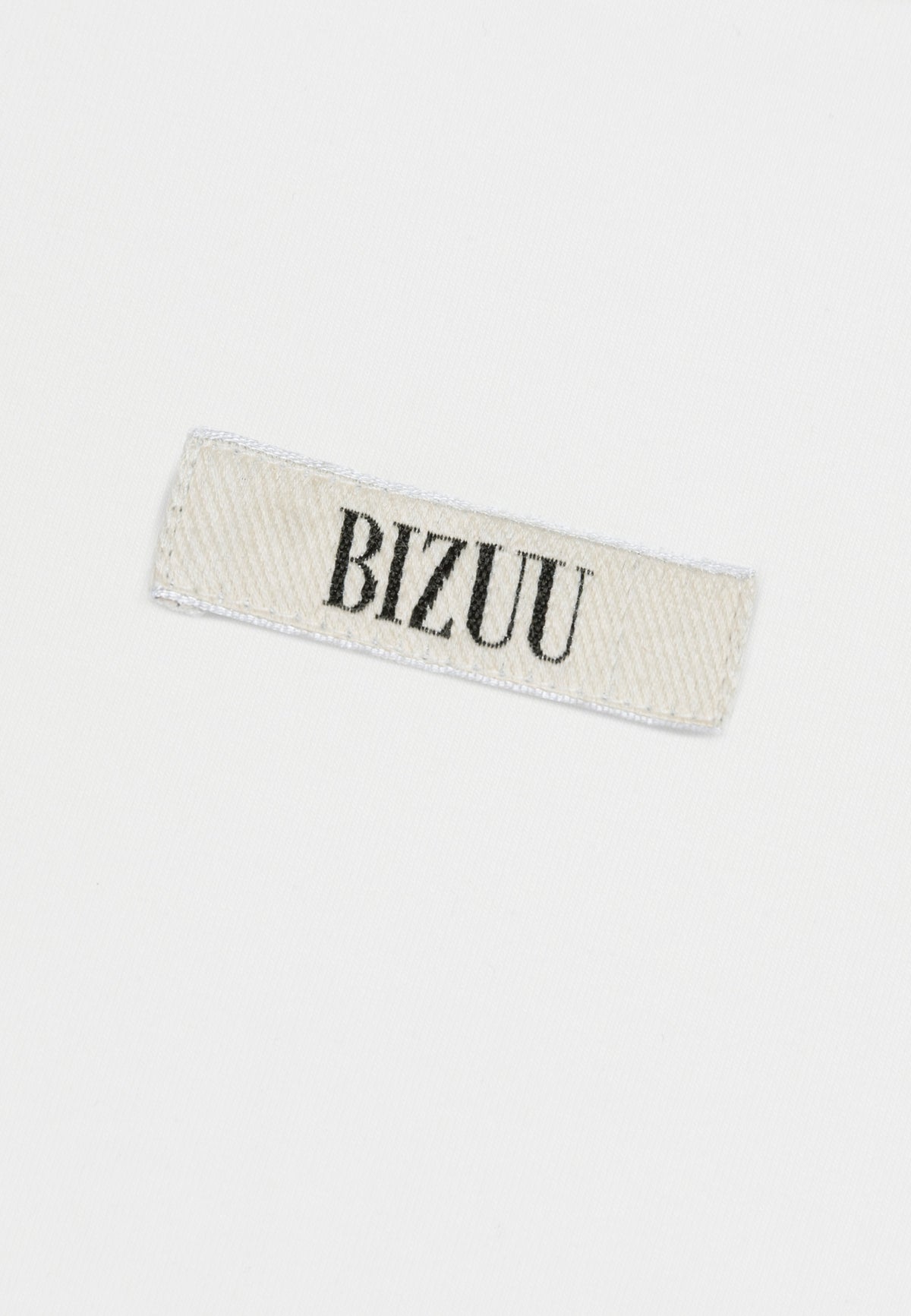 Close-up of the Bizuu logo on the front of the cream TISHALLE T-shirt.
