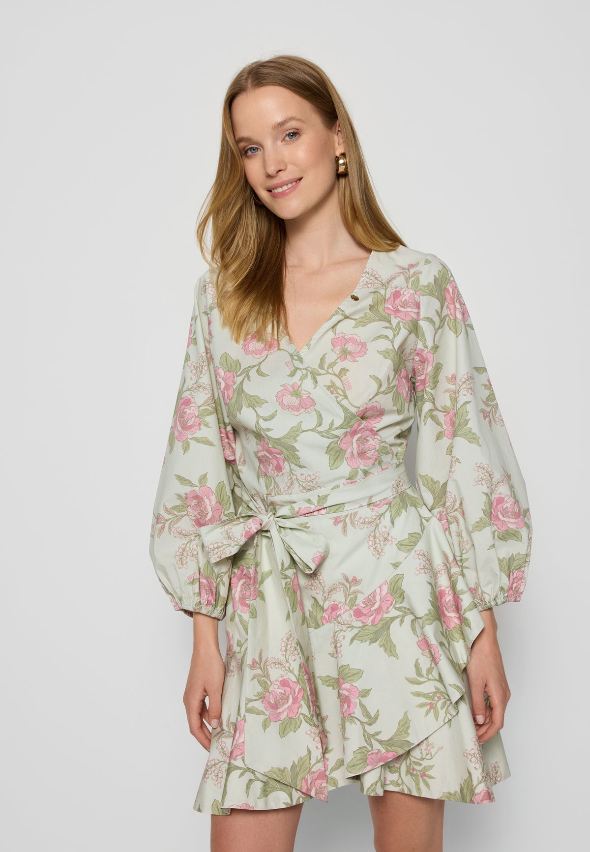 Close-up of the top of the AMROSIA dress with buff sleeves and a bow at the waist, in a pastel floral print.