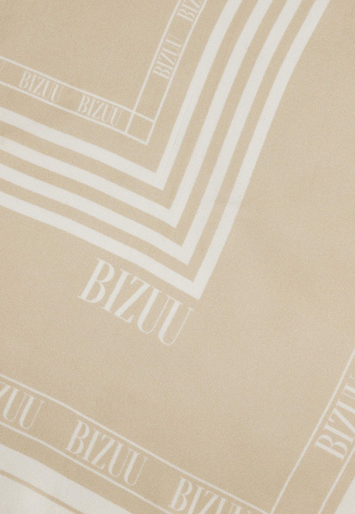 Close-up of the logo on the beige ARIA silk scarf.