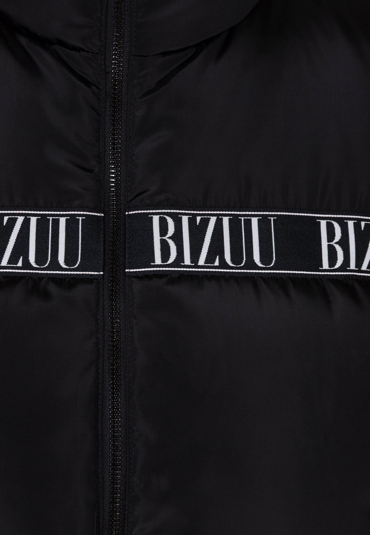 Close-up of the logo tape on the black AYASE down vest.