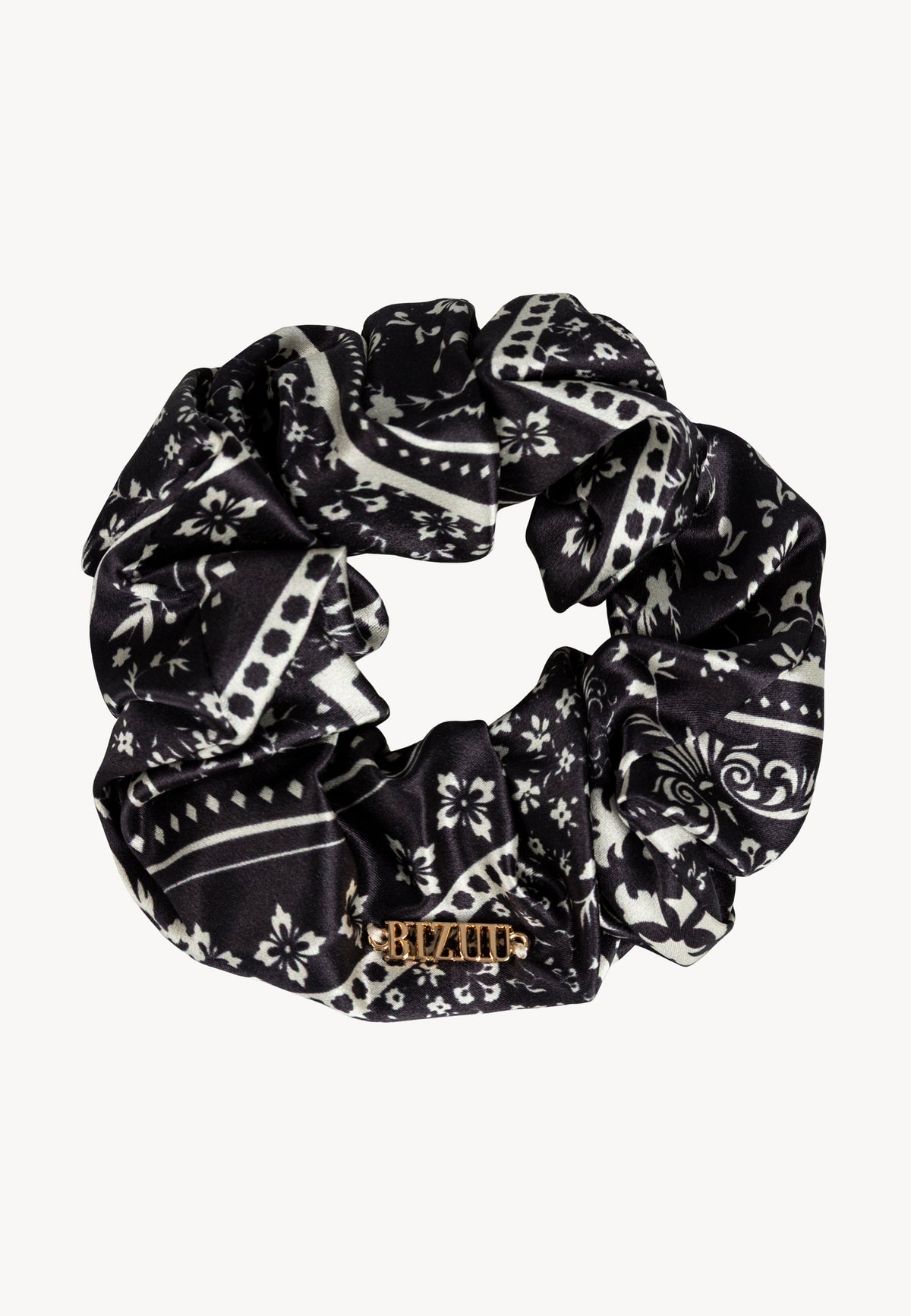 BANDI silk scrunchie with white floral print on a black background.