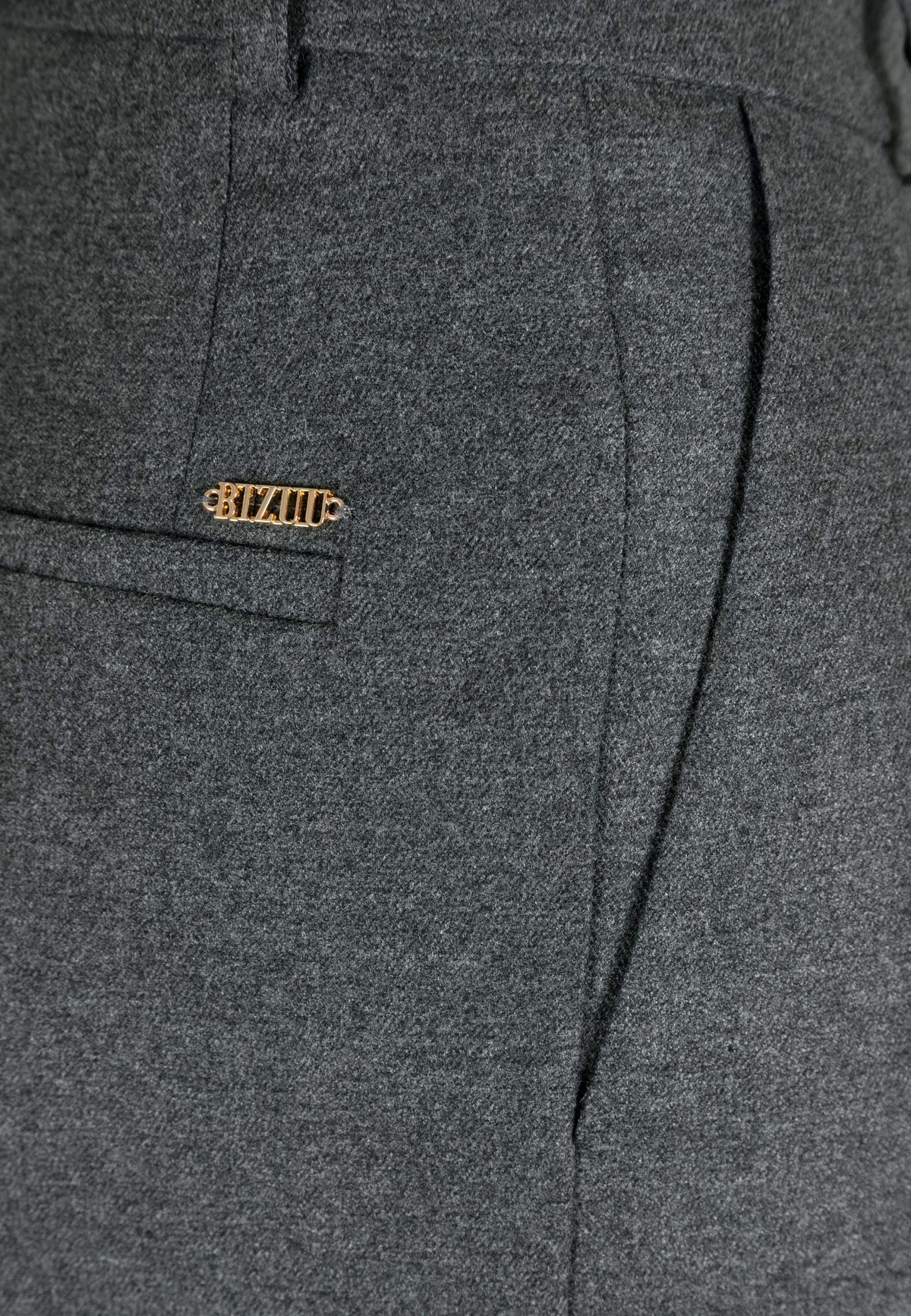 Close-up of the decorative golden letters above the imitation back pocket on the graphite BANOS trousers.