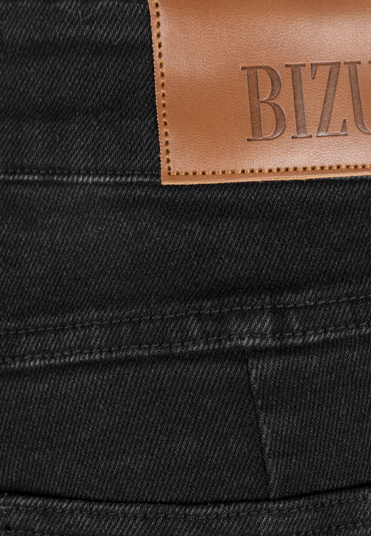 Close-up of the Bizuu logo label on the back of the BELINNA pants.