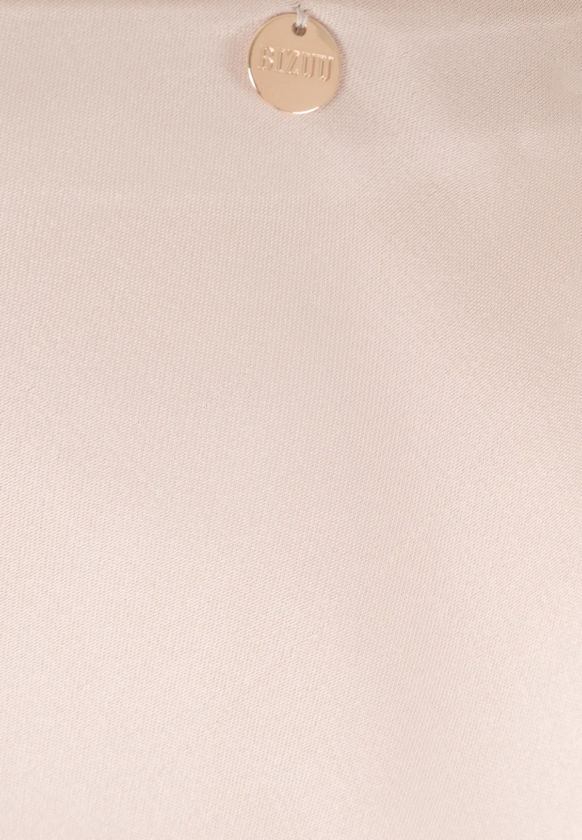 Close-up of the decorative BIZUU medallion at the waist of the BREE skirt.