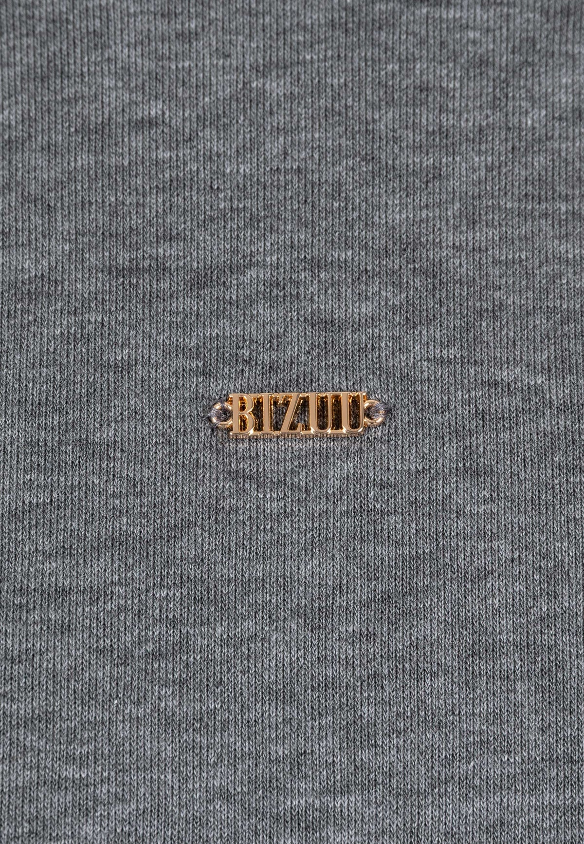 Close-up of the gold logo on the front of the CAGLIARI knit dress.