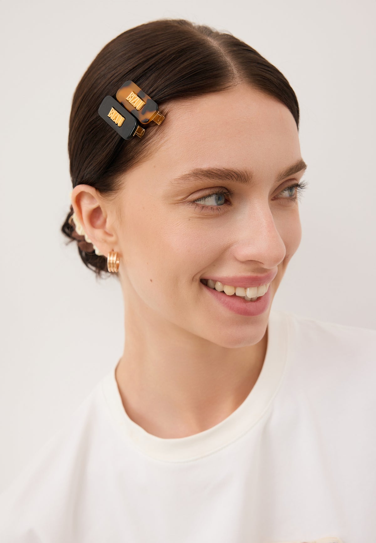 Close-up of the model’s hair styled with two small CATTA clips in black and brown.