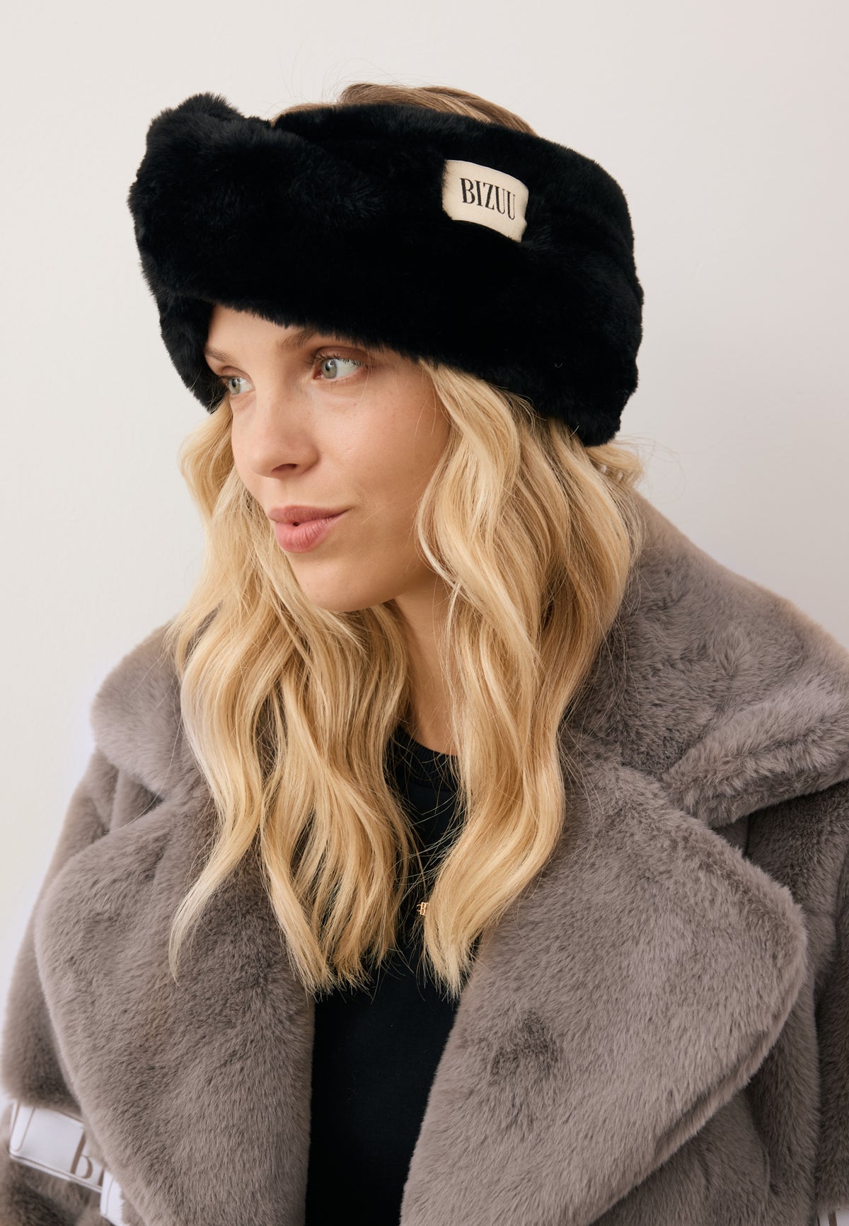 Close-up of the model wearing the black faux fur FEMI headband.