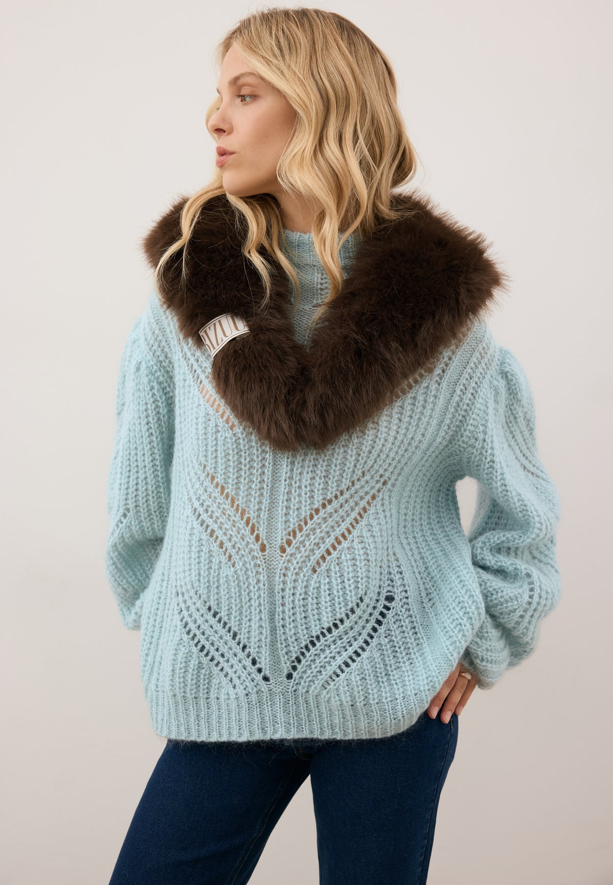 Model looking to the side wearing the ROSSO sweater and the brown faux fur FLOOFU scarf.