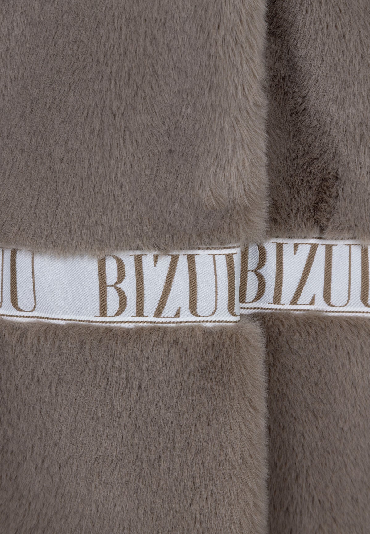 Close-up of the branded tape on the taupe FLORENCE fur coat.