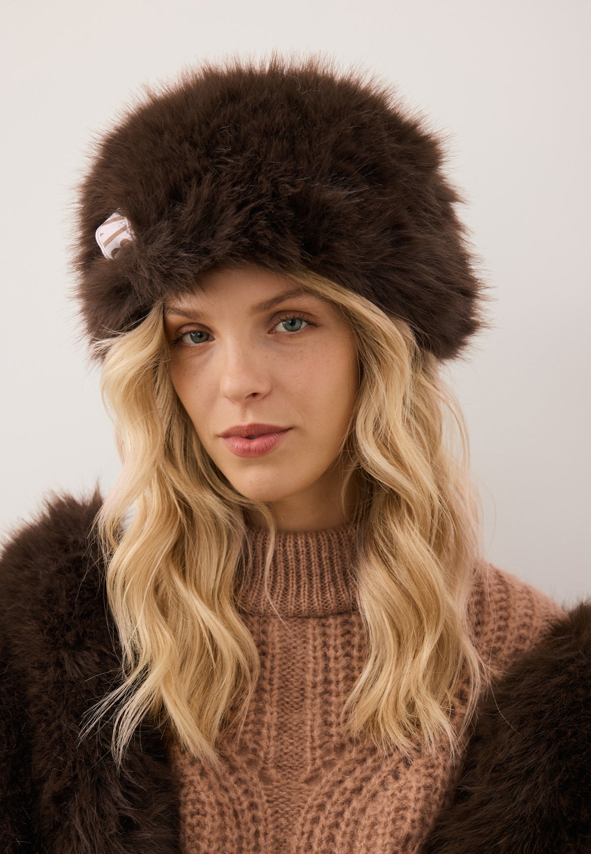 Close-up of the model wearing the brown faux fur FURRA hat.