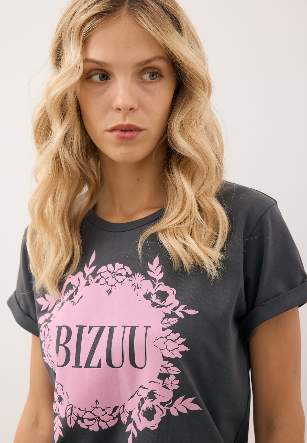 Close-up of the pink appliqué with BIZUU logo on the graphite IOLA T-shirt.