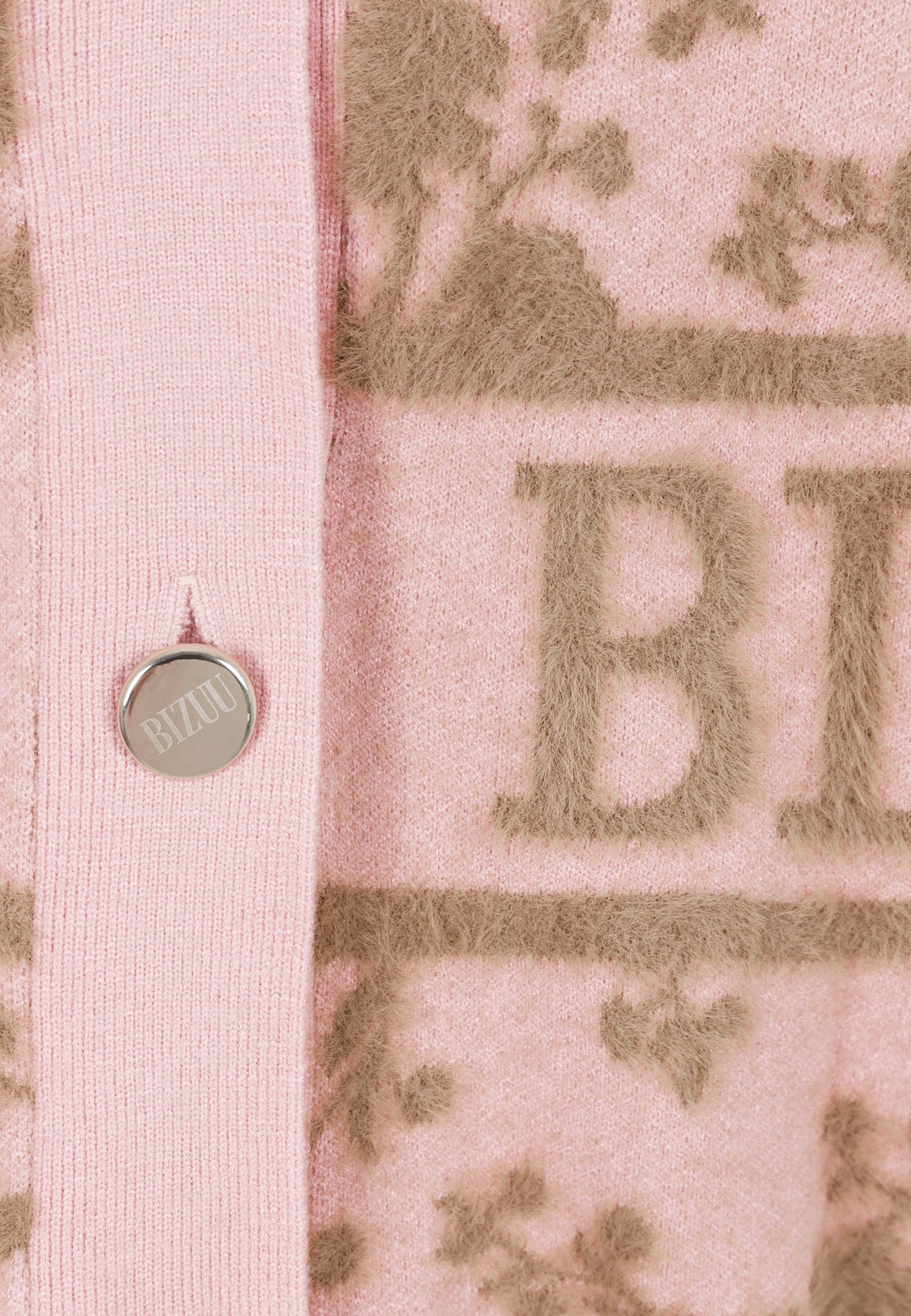 Close-up of the 3D appliqué and branded buttons on the LANZAR sweater.
