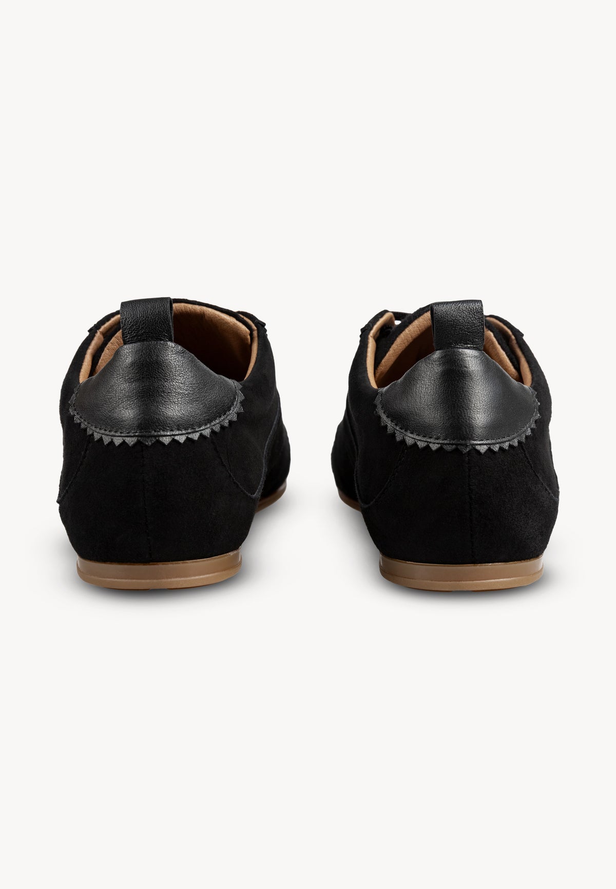 Black LEOLA sneakers seen from behind, close-up of decorative leather on the heel.