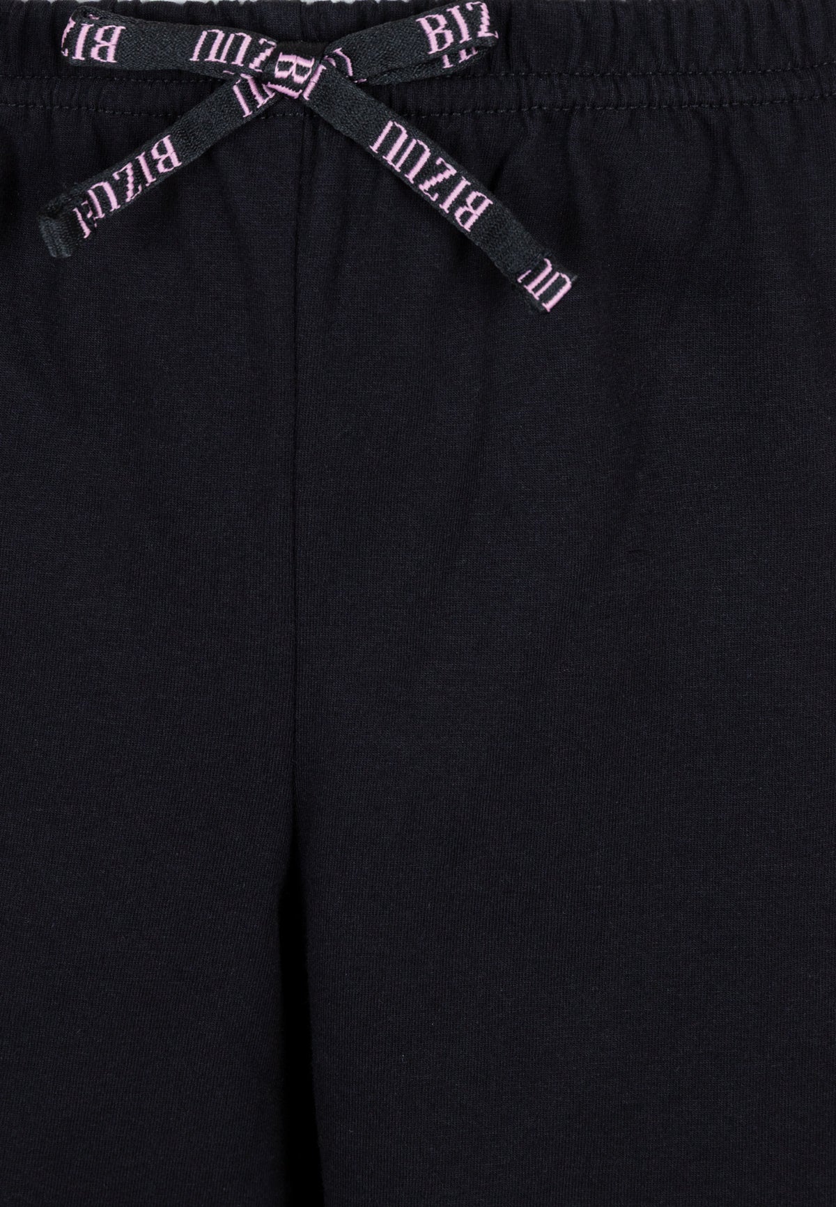 Close-up of the logo bow on the waistband of the LIMA pajama shorts.