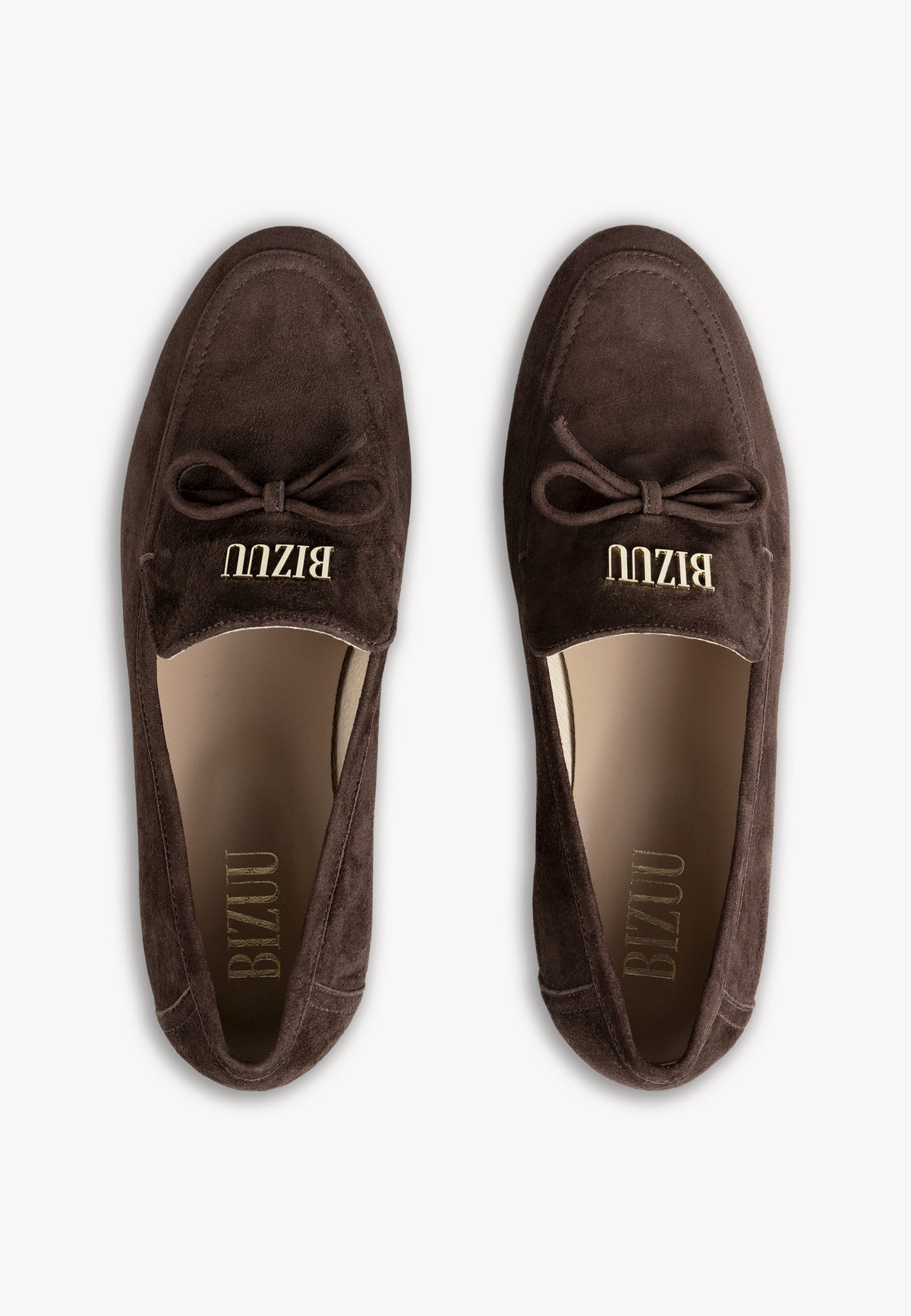 Brown suede LISANA moccasins standing on a leather chair.
