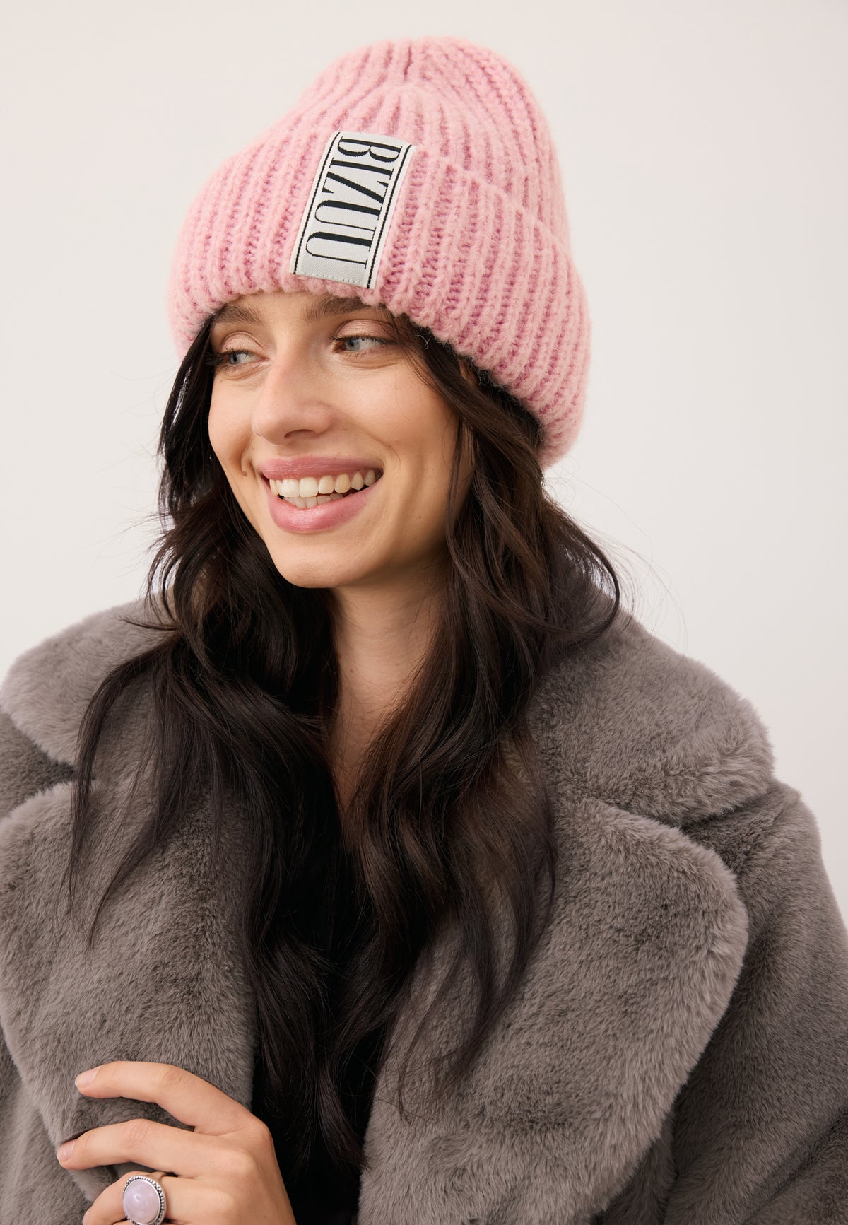 Smiling model wearing a pink LORRO cap with a logoed label on the front.