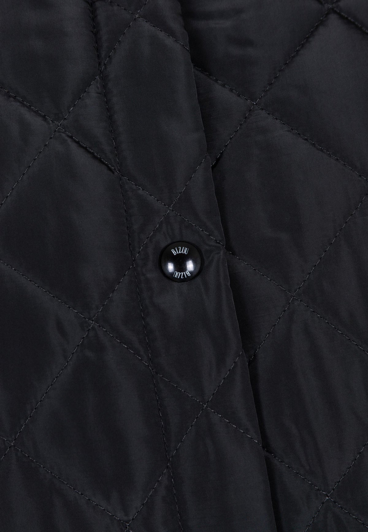 Close-up of the branded snap buttons on the MAREVIA quilted coat.