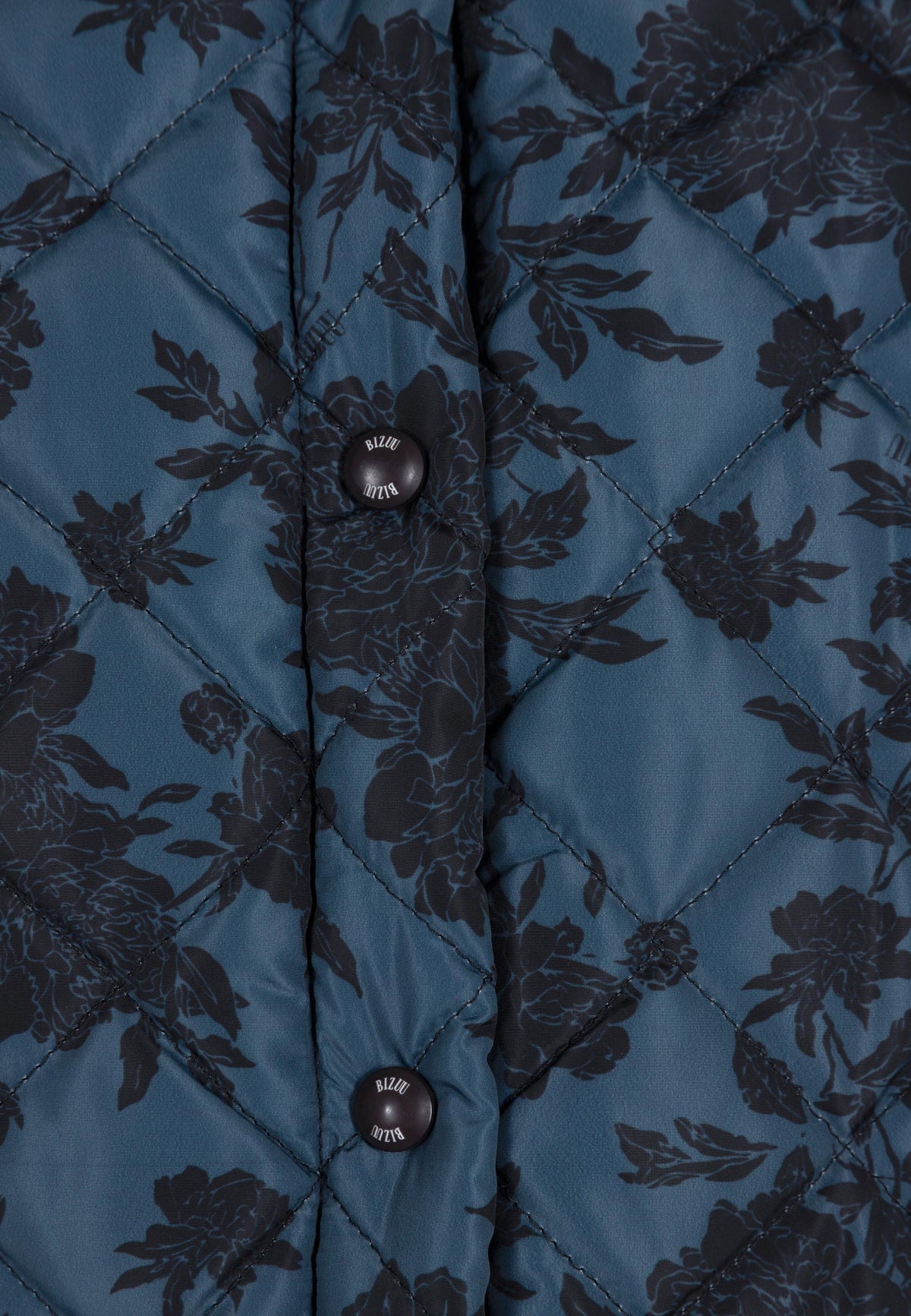 Close-up of Bizuu logo snaps on MARIN quilted jacket.