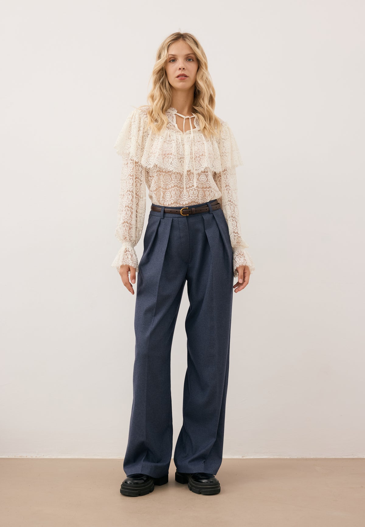 Model wearing the lace MARLY blouse and navy BANOS wide-leg trousers.