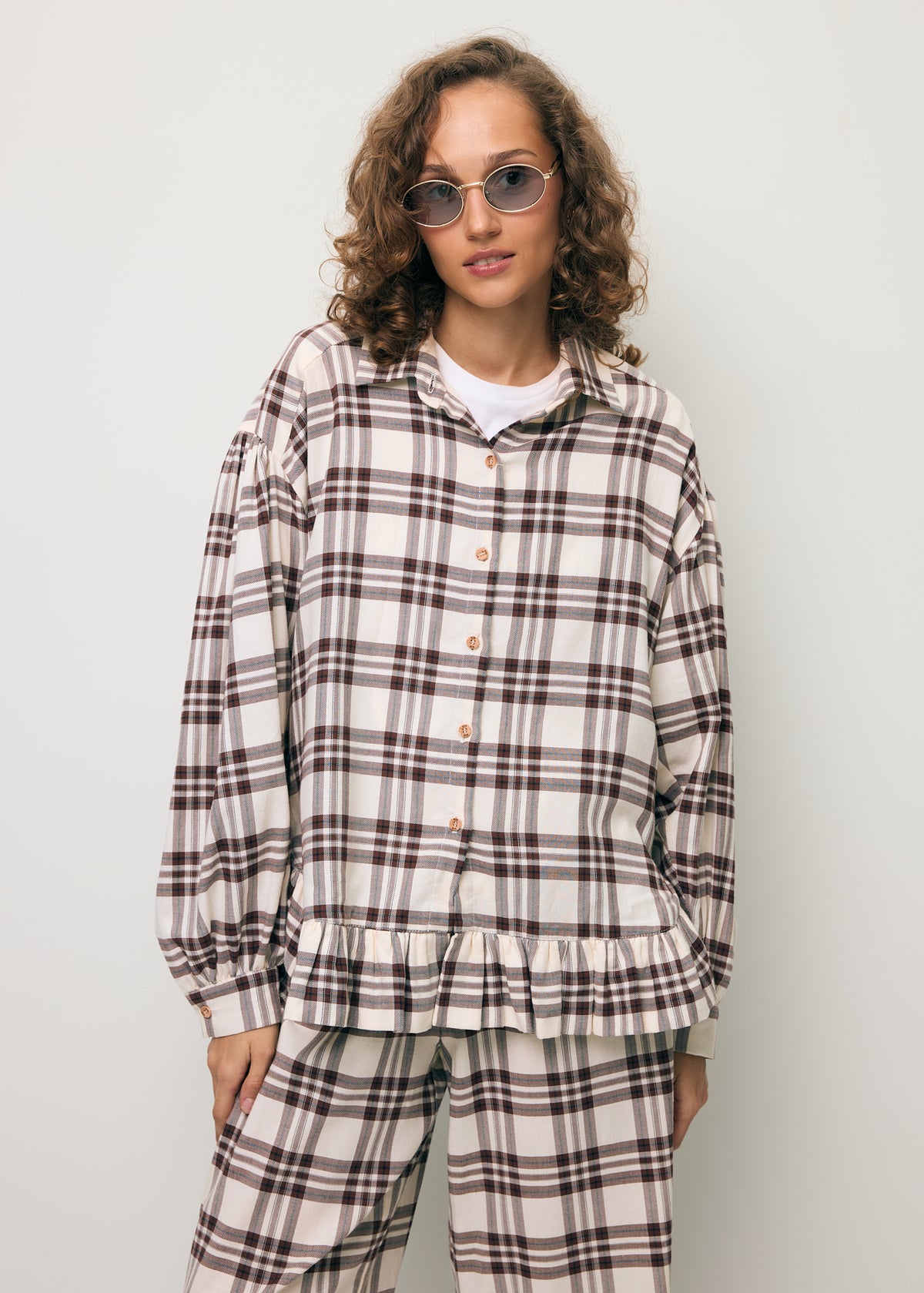 A model wearing a checkered FALBI shirt with a decorative ruffle.