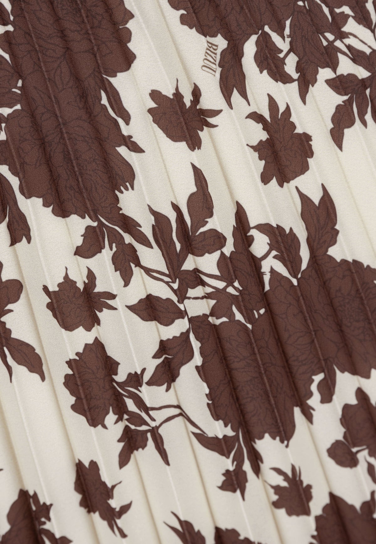 Close-up of the pleats and brown floral print on the MINA skirt.