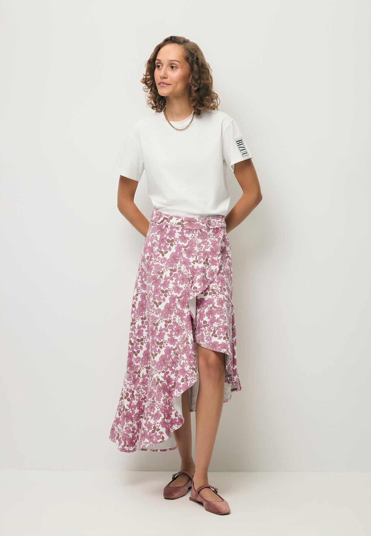 A model wearing the NIIAM printed asymmetrical skirt and the TISHAM basic T-shirt.