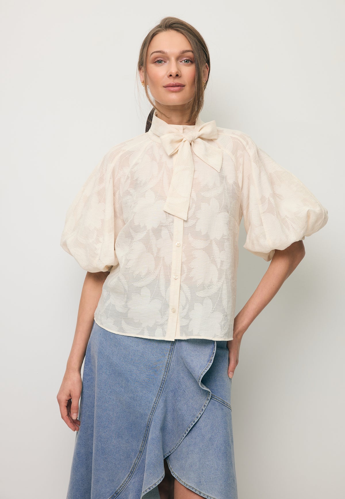 Close-up of a model wearing the cream AZALEA blouse in a floral pattern.