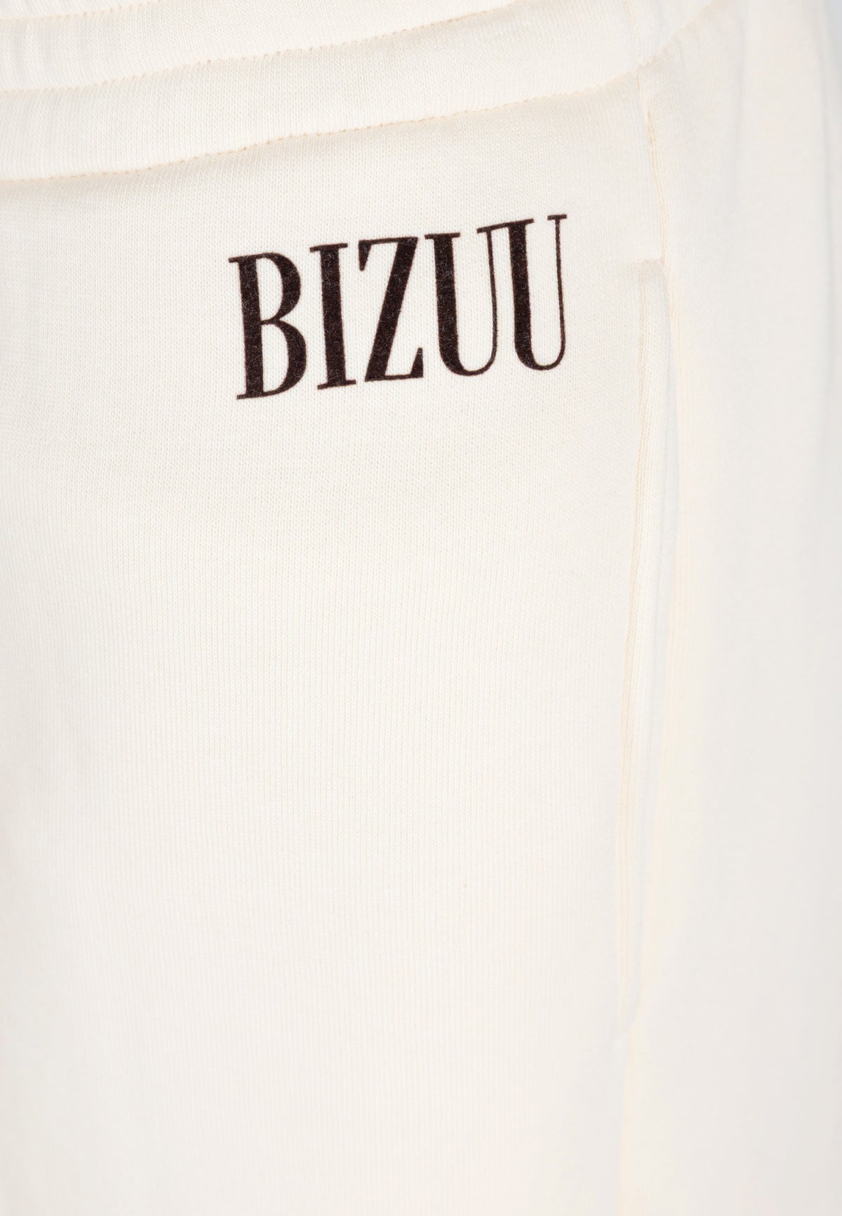 Close-up of the black logo on the front of the PETRA pants.