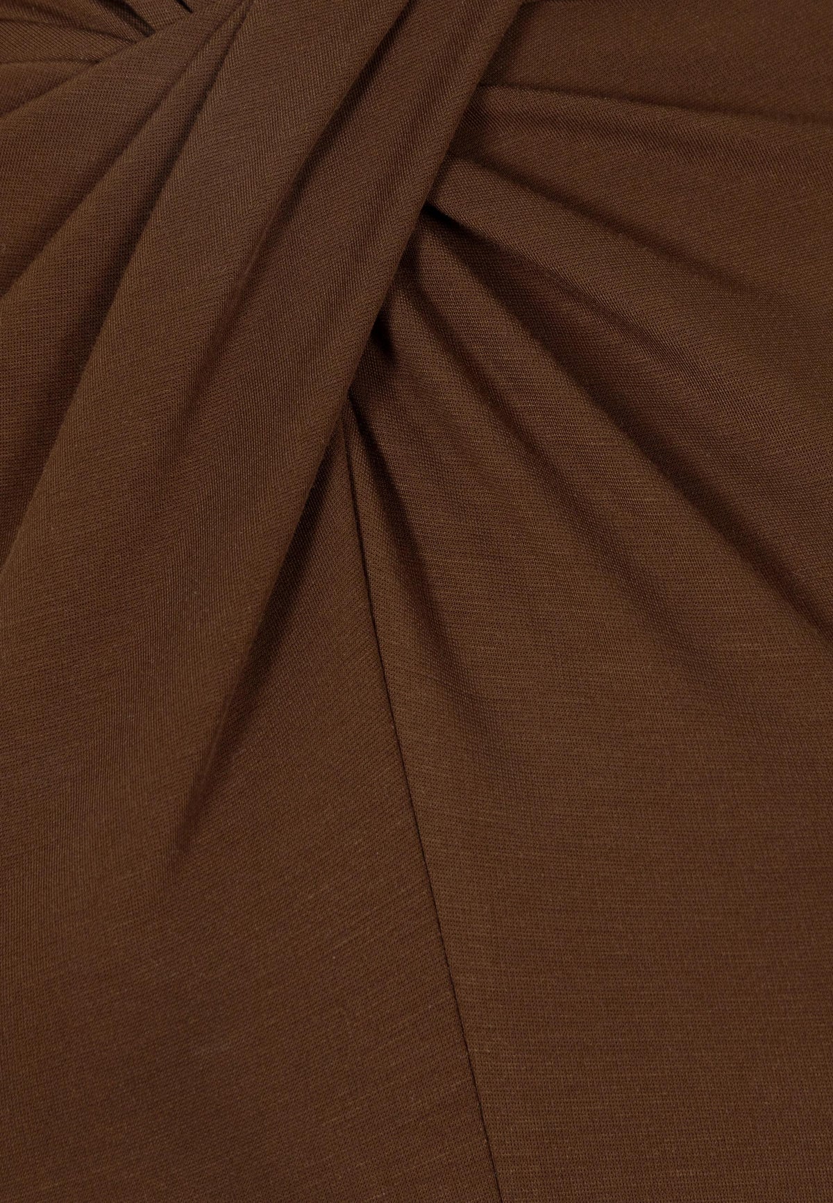 Close-up of the twist detail on the front of the brown PINOWA long-sleeve.