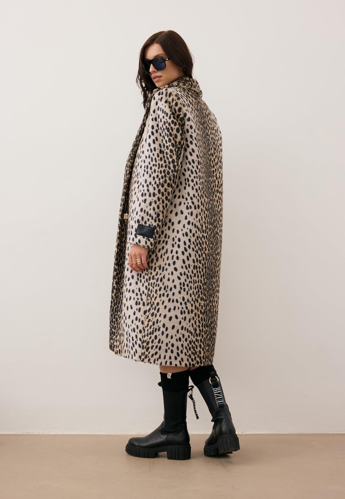 Model standing with her back turned, wearing the spotted PONTICELLI faux fur coat.