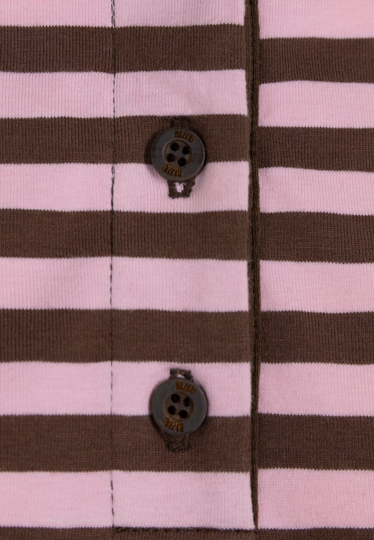 Close-up of the buttons of the RAYA sweatshirt with brown and pink stripes.
