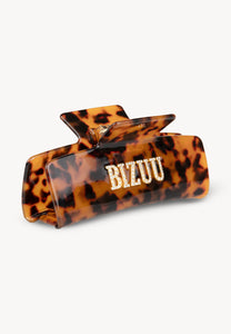 Brown RHODI hair clip with logo.