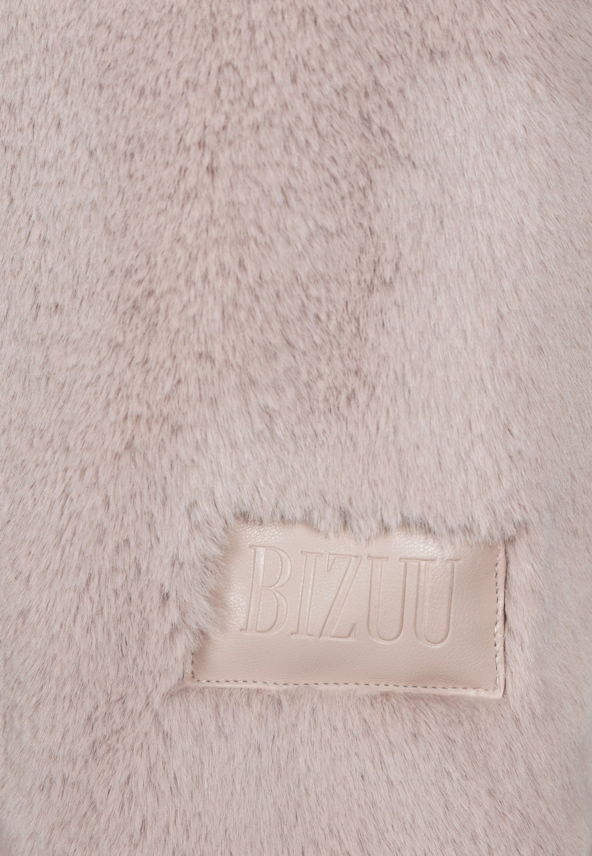 Close-up of the embossed logo on the sleeve of the beige ROMA coat.