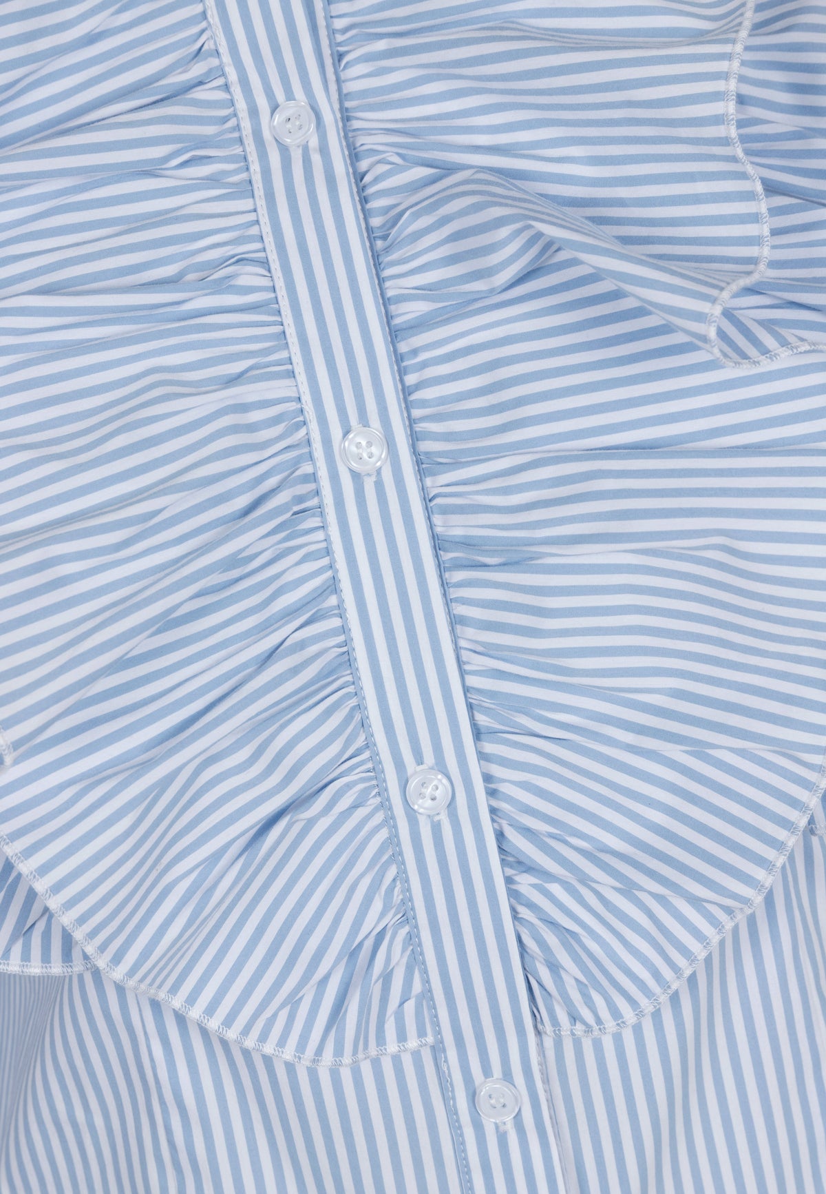 Close-up of buttons and ruffles on the blue SANNI shirt.