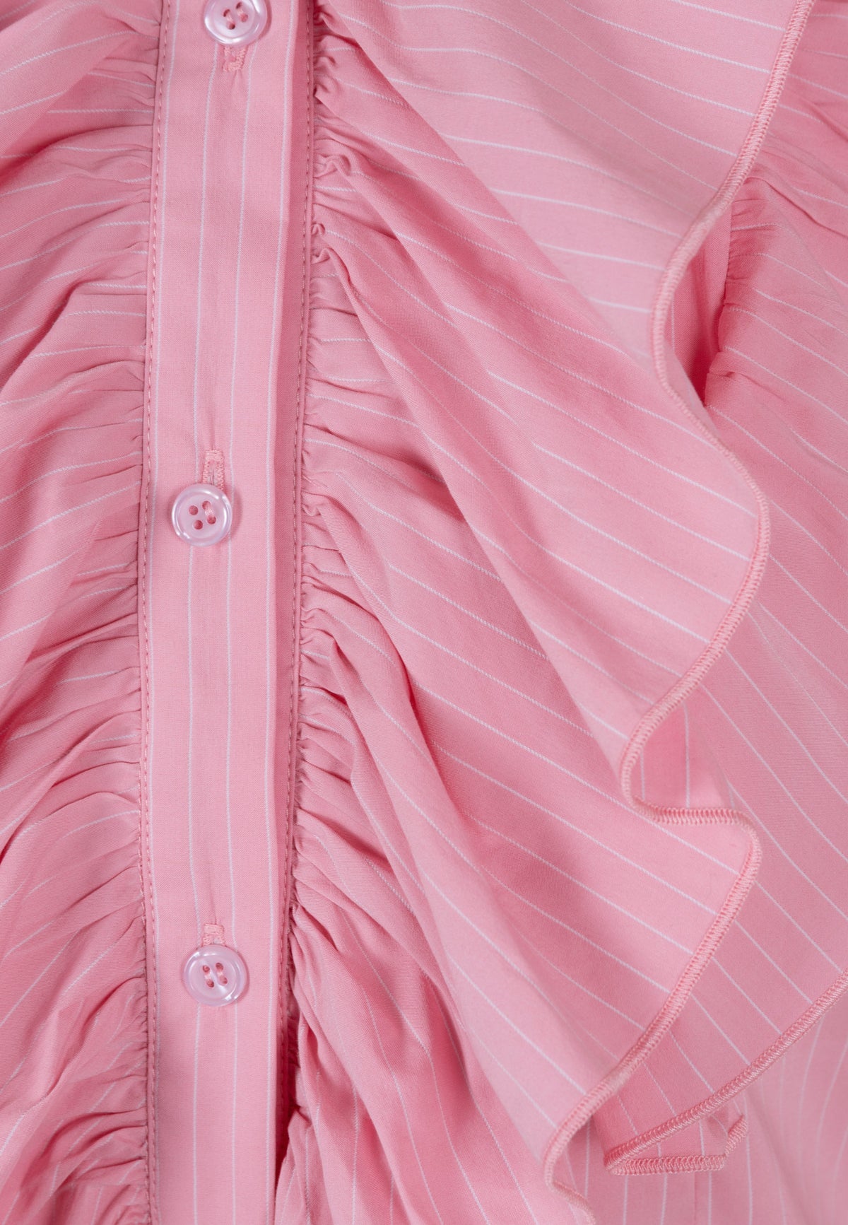 Close-up of the ruffles on the pink SANNI shirt.